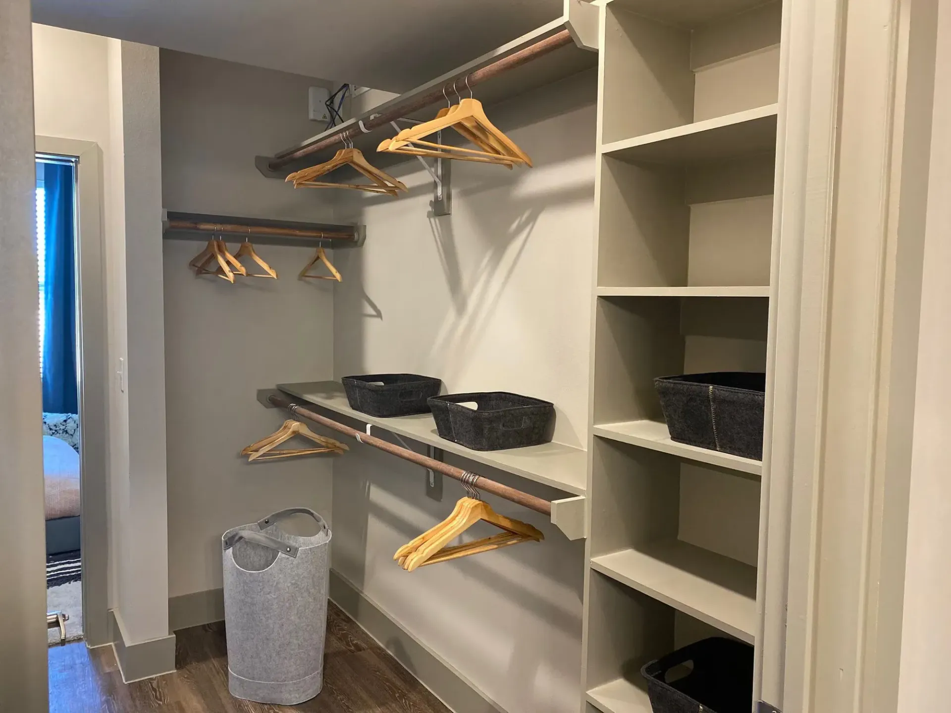 Walk-in closet with shelves, hanging rods, and fabric storage baskets.