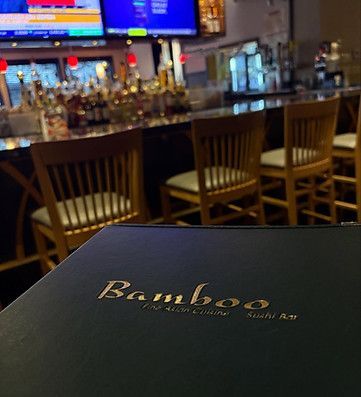餐厅酒吧内部，菜单上写着 Bamboo。两台电视播放着节目，环境舒适。