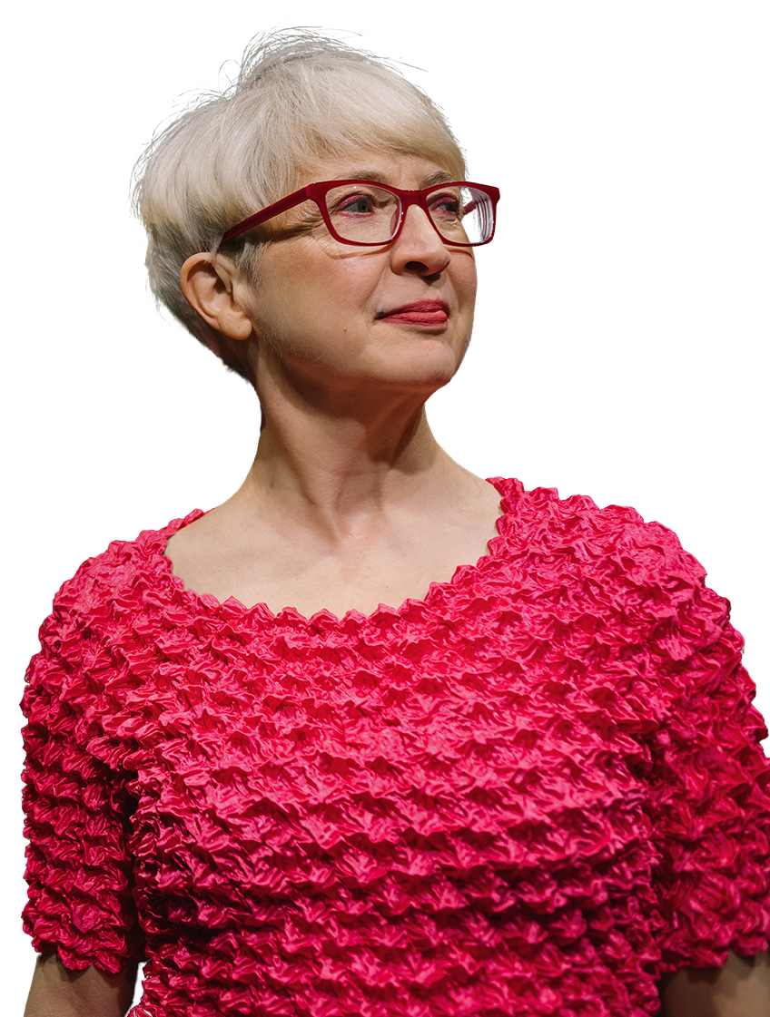Andrea wears glasses and a pink top.