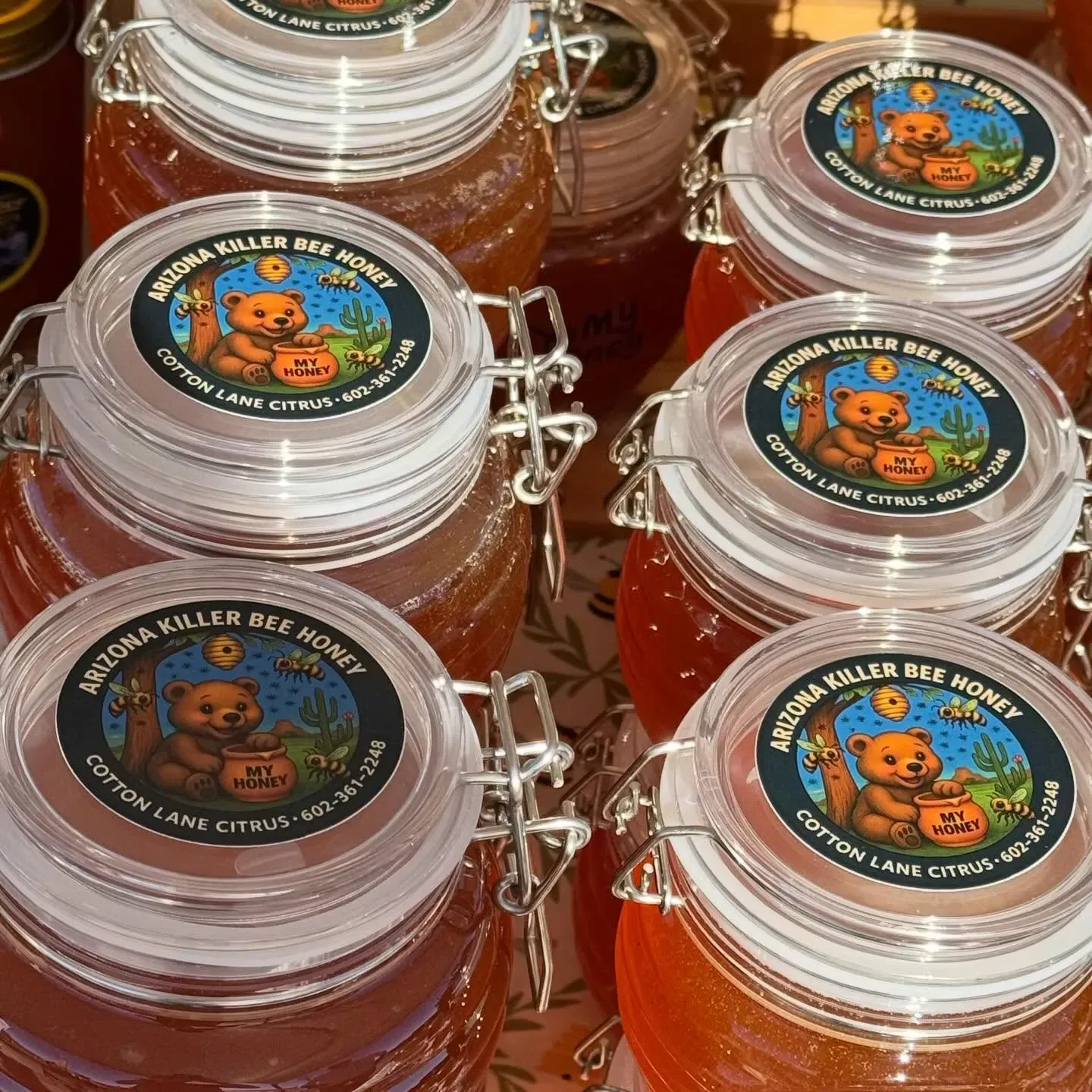 Small glass jars of amber liquid with round cartoon bear labels stacked in a display.