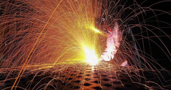 Bright sparks and orange fireworks burst in the dark with a glowing central flare