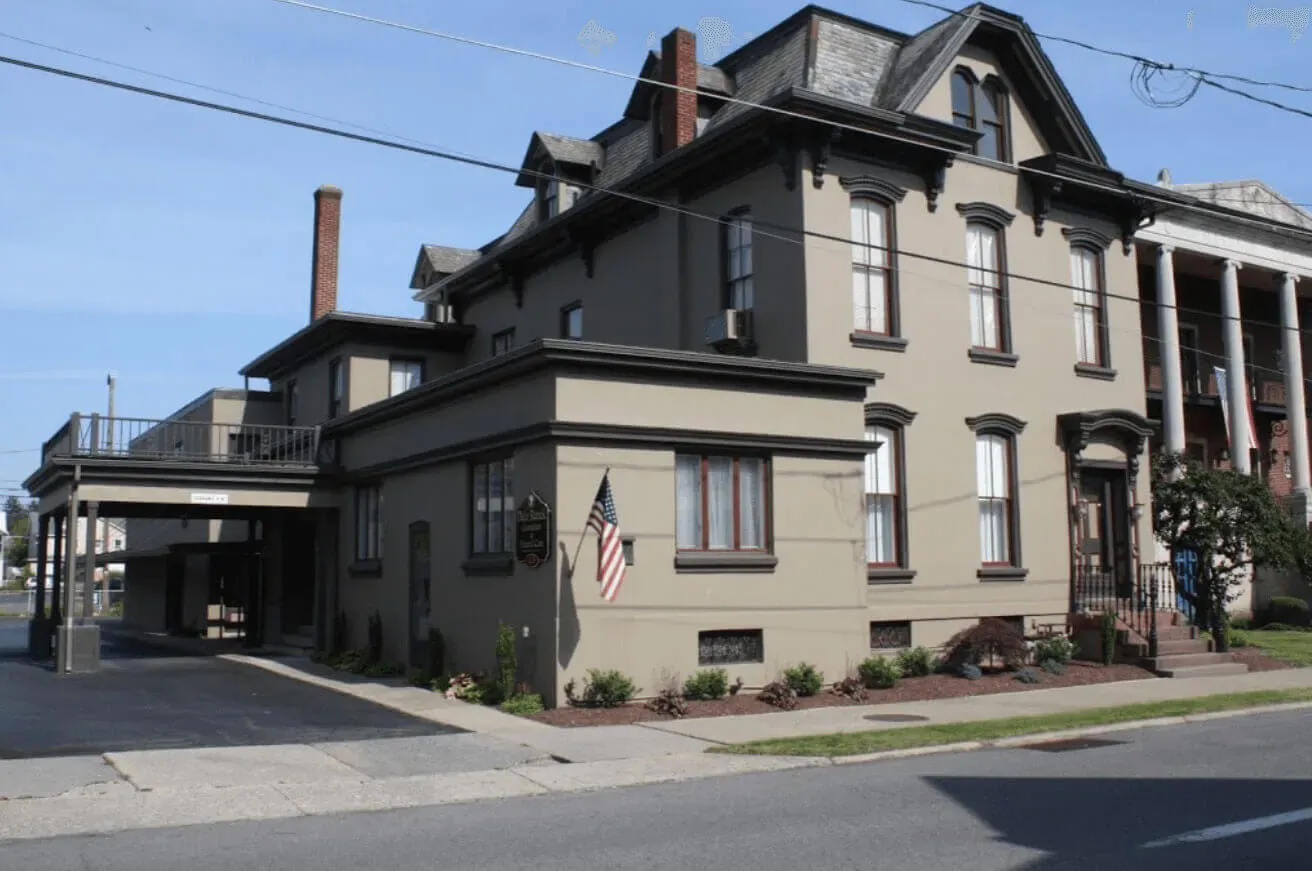 Historic funeral home with traditional architecture on a sunny day, offering compassionate care.