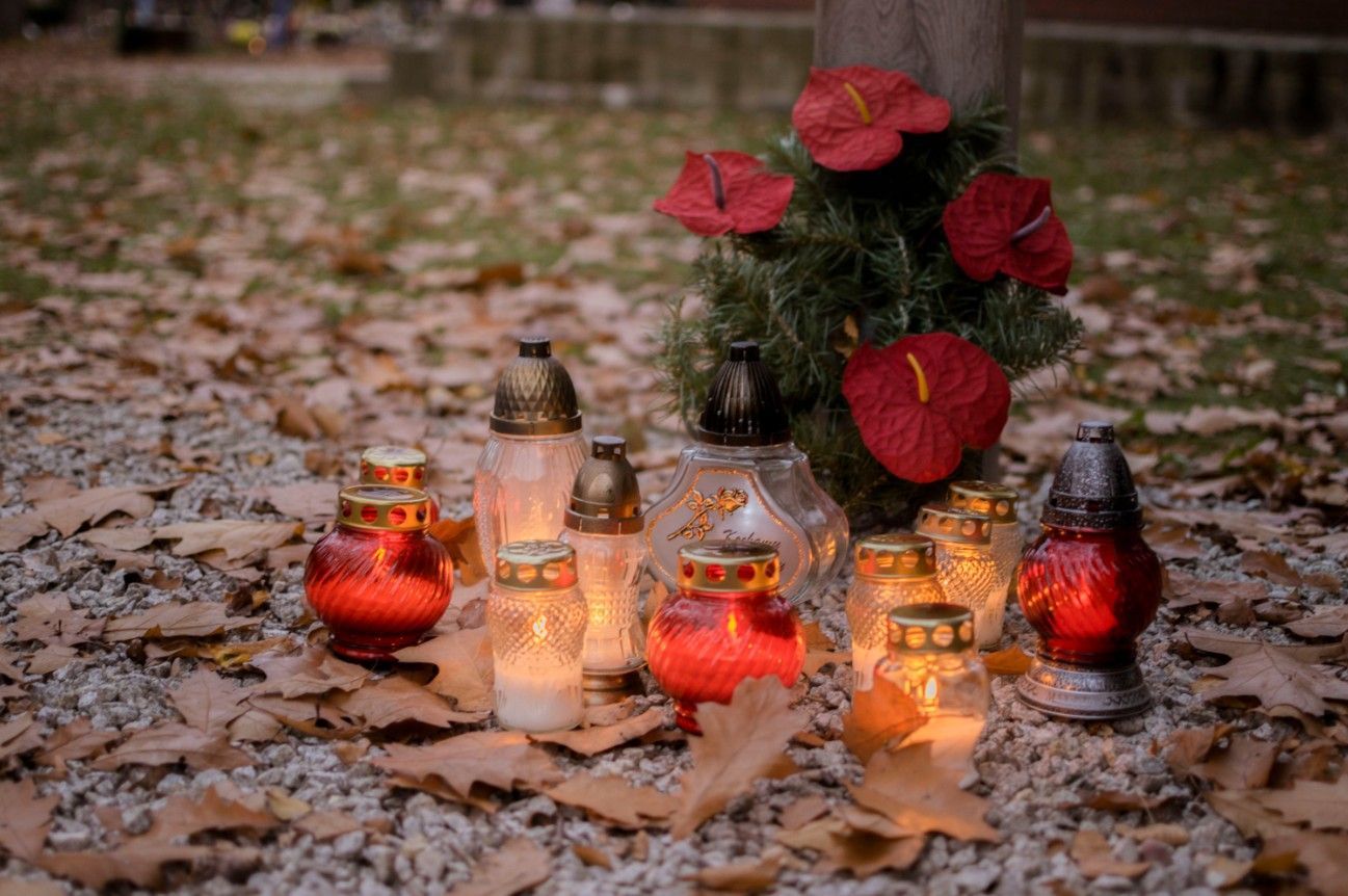Memorial candles and red flowers arranged at a gravesite in Watsontown, PA