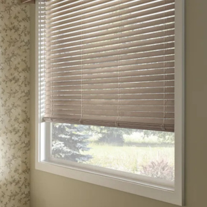 Partially closed beige window blind with sunlight filtering through