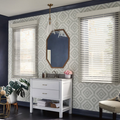 Stylish room with patterned wallpaper, two windows, gold mirror, white console, plant, and bench