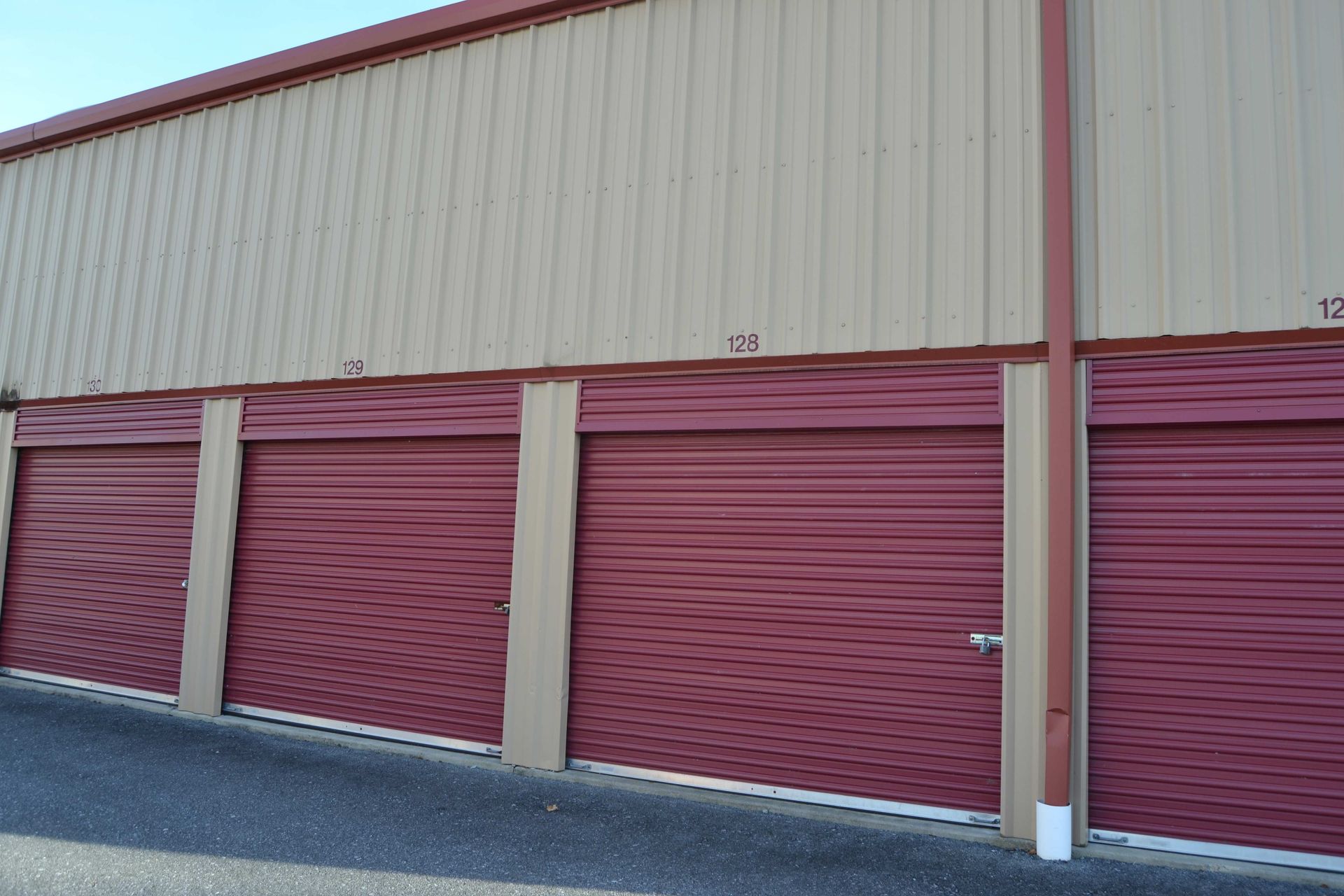 A row of red garage doors on the side of a building.
