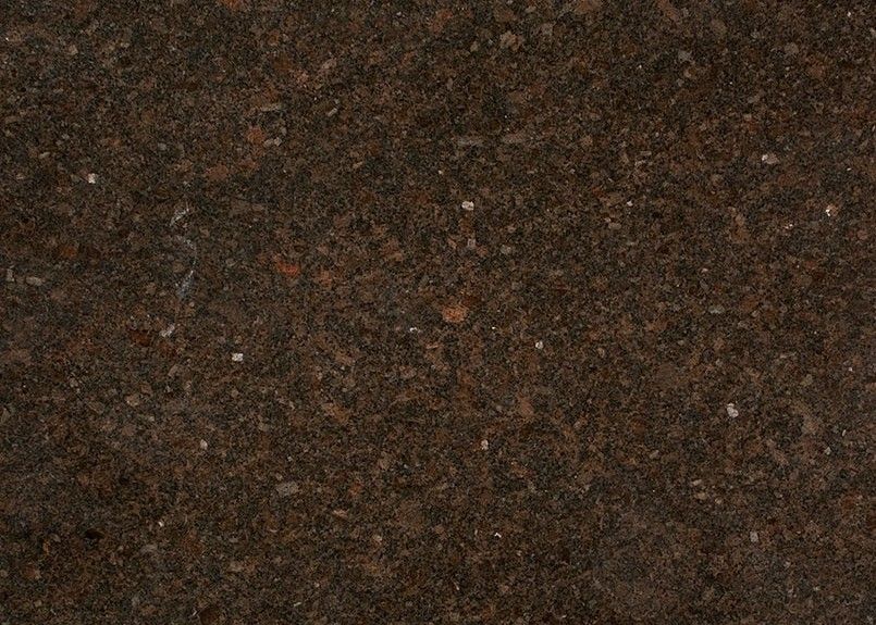 Close-up of a rough, dark brown textured surface with small flecks of lighter colors.