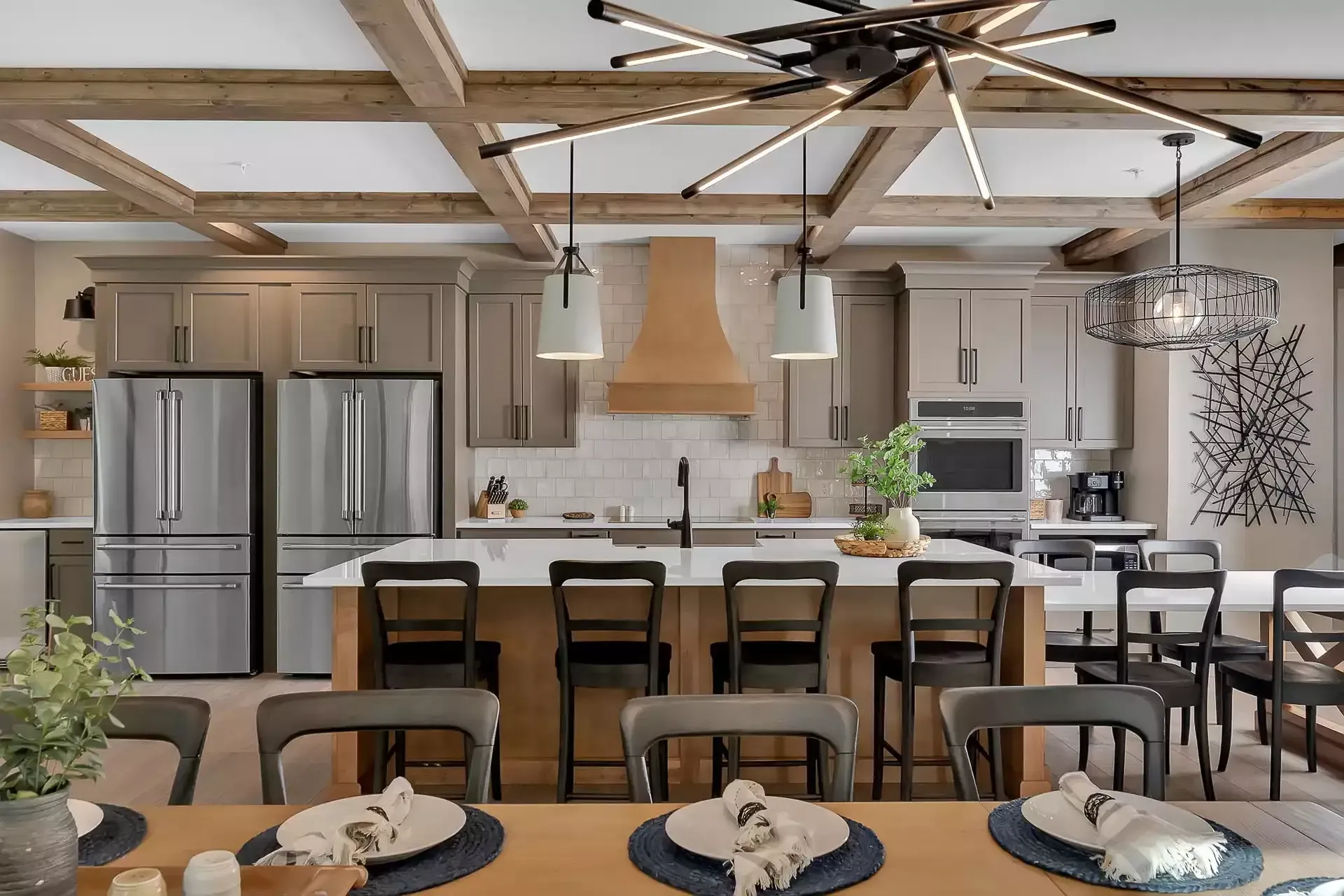 Modern kitchen with island, stainless steel appliances, and wooden beams.