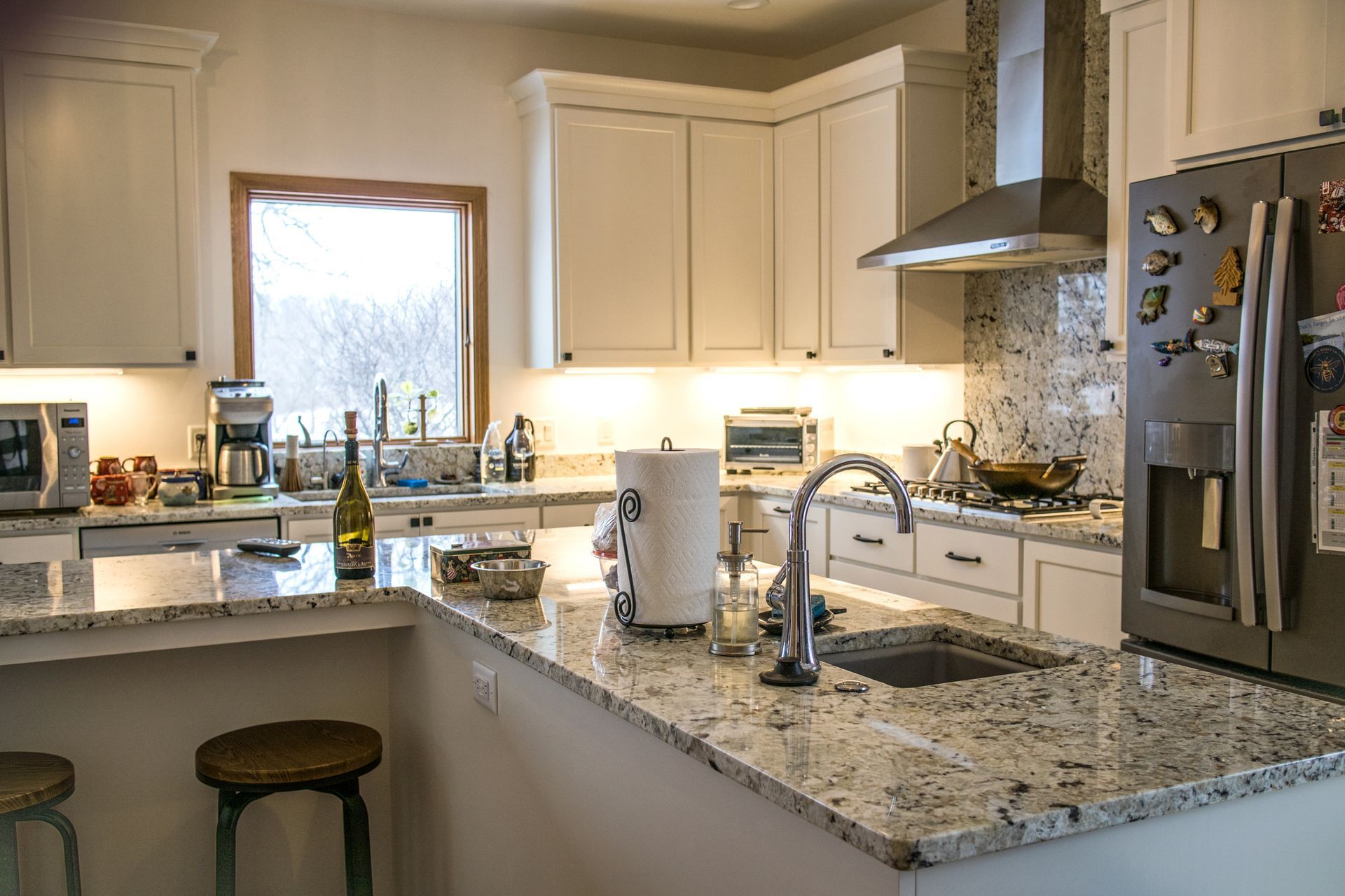 A kitchen features white cabinets and