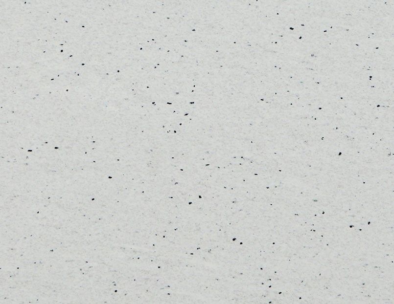 Light gray textured surface with scattered dark flecks.