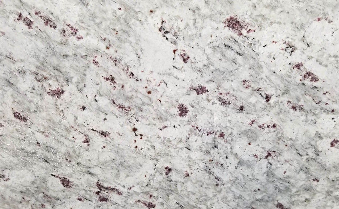 White granite with gray veining and scattered dark red flecks.