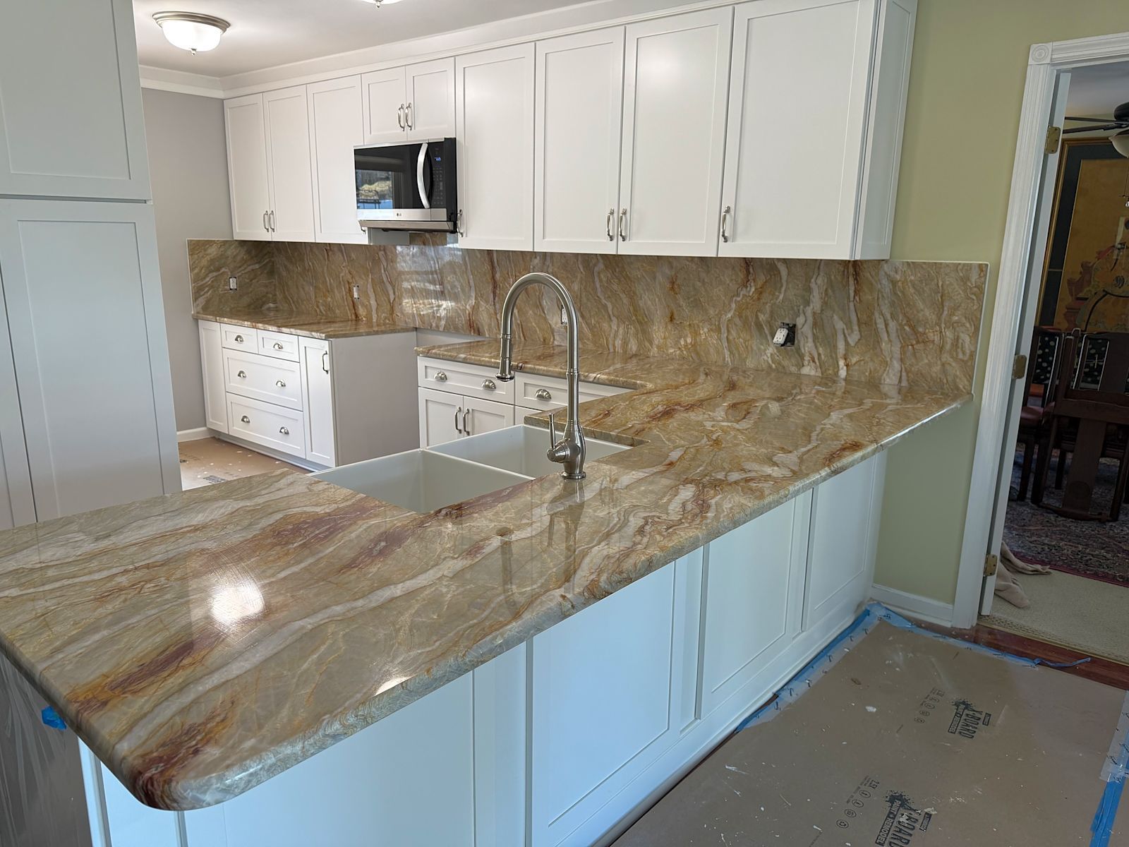 White kitchen cabinets with granite countertops.