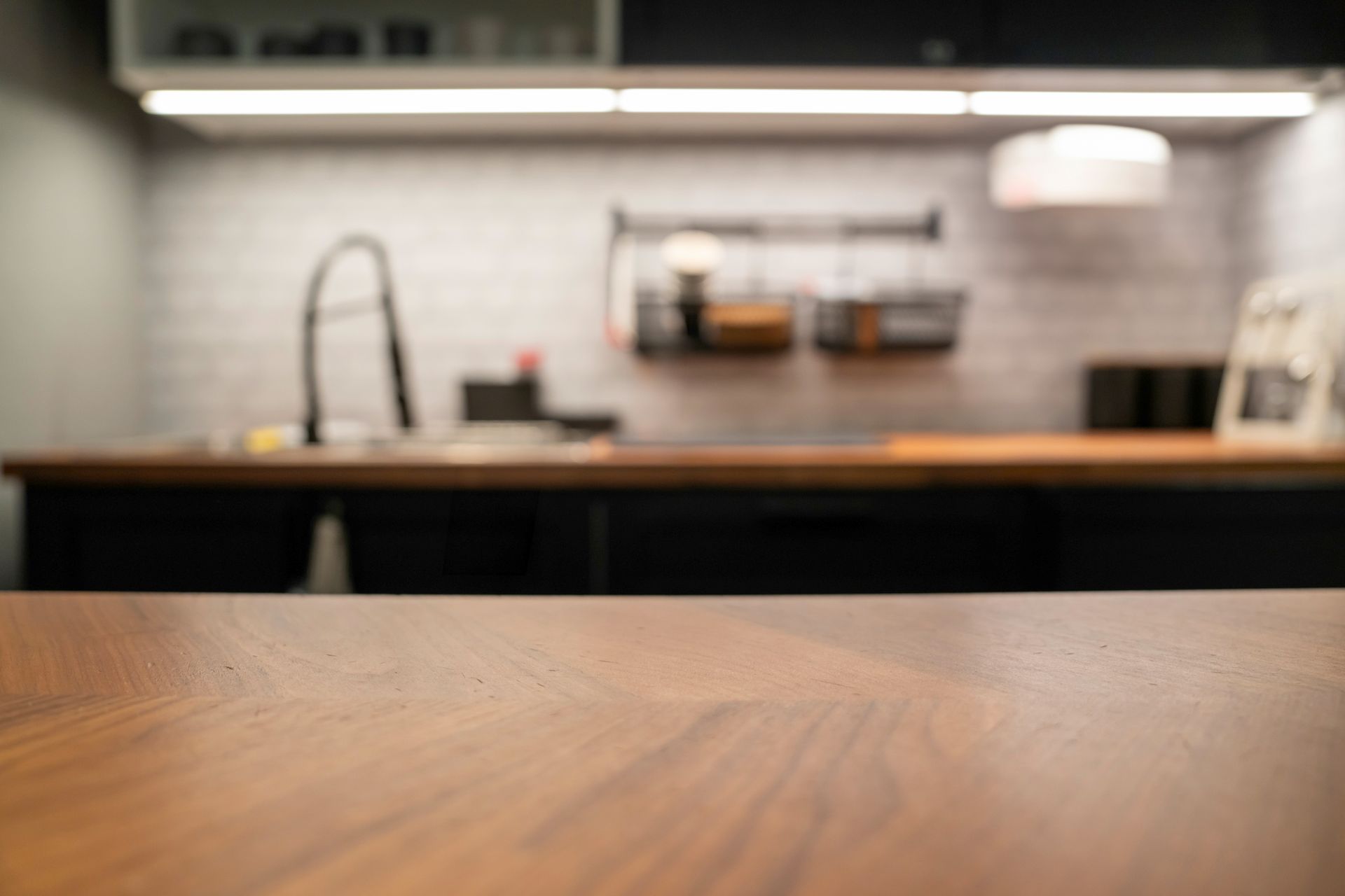 Wooden countertop in focus, kitchen background blurred.