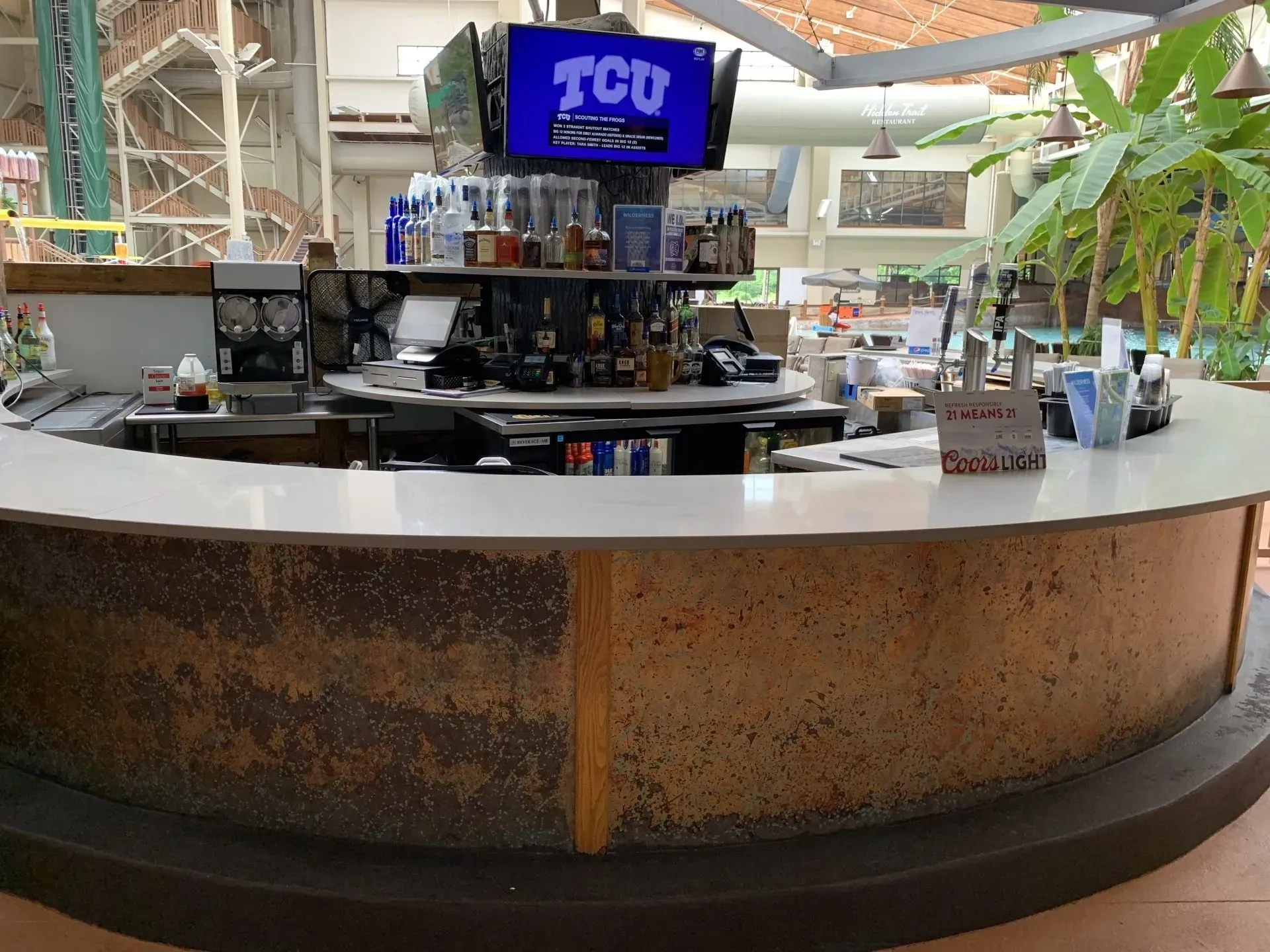 Bar with a white countertop and a TV displaying 