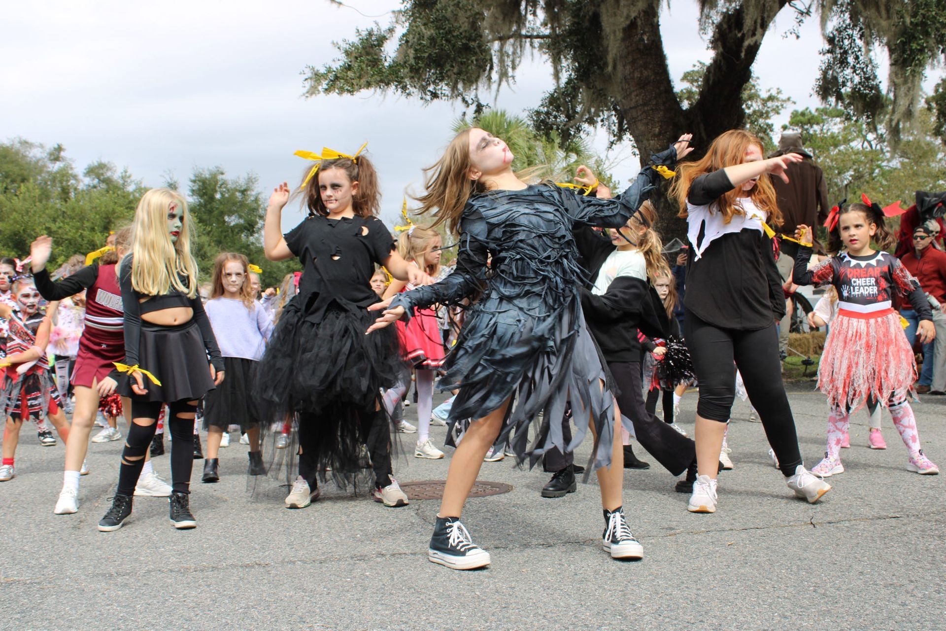 Children in costumes dancing outdoors at a Halloween event