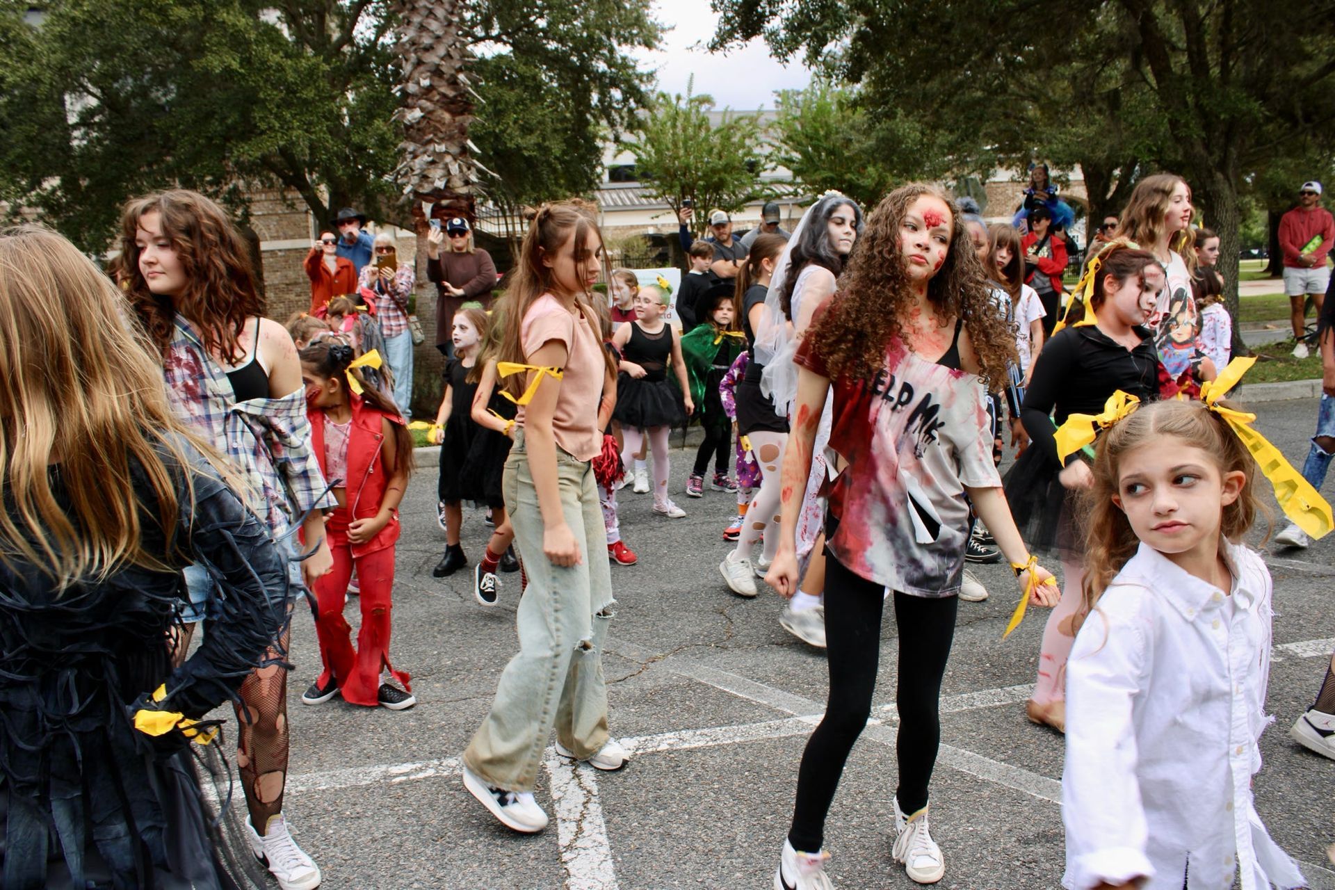 Children dancing outdoors in colorful costumes at a lively street festival