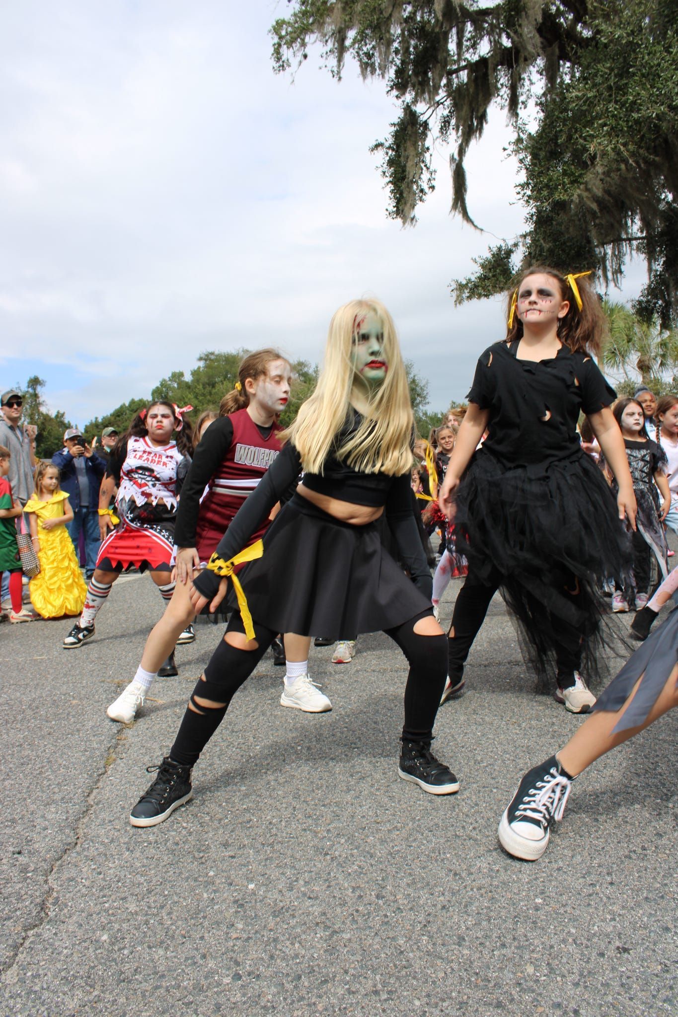Costumed dancers performing outdoors on a street during a parade