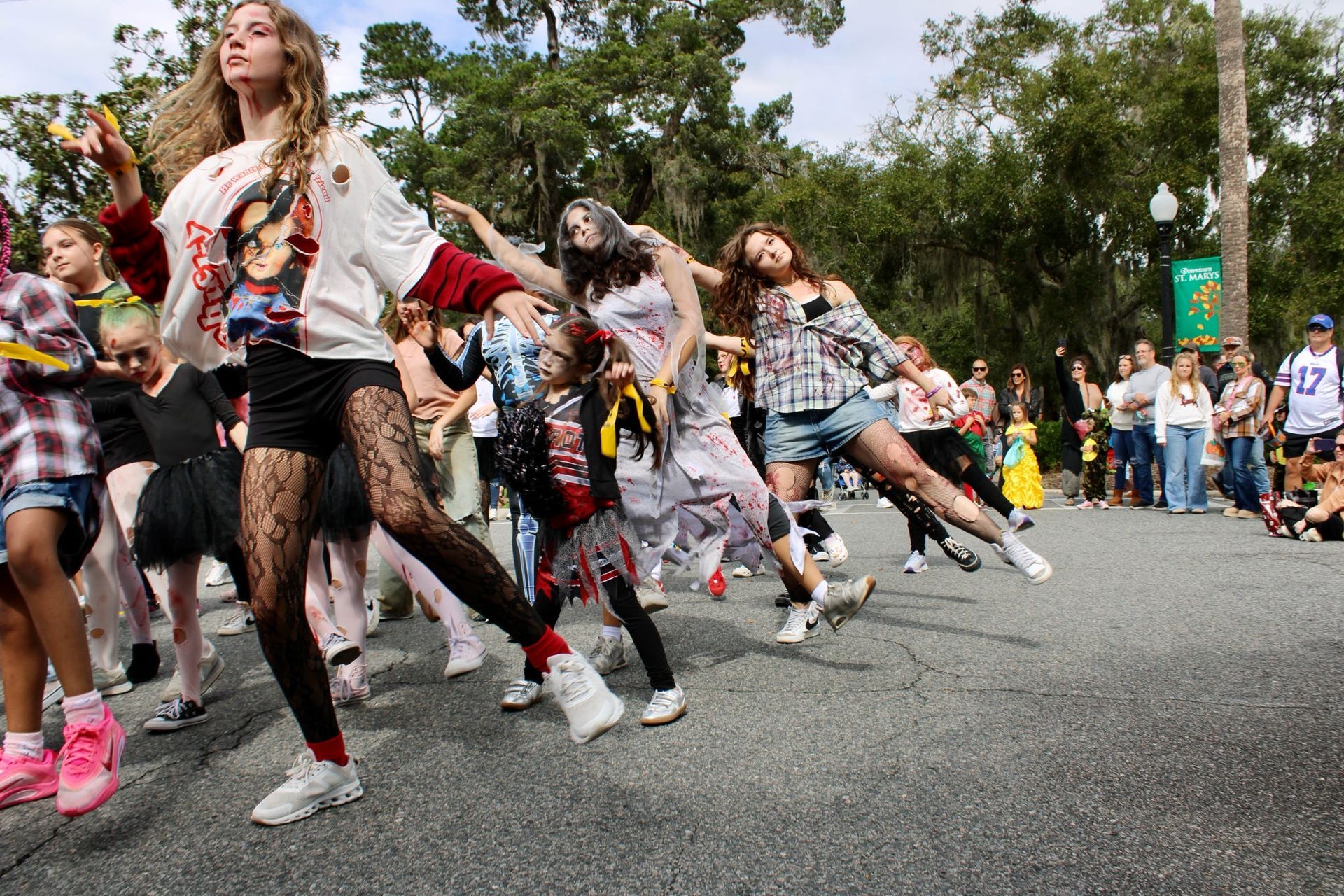 People dancing in colorful costumes on a city street during a parade