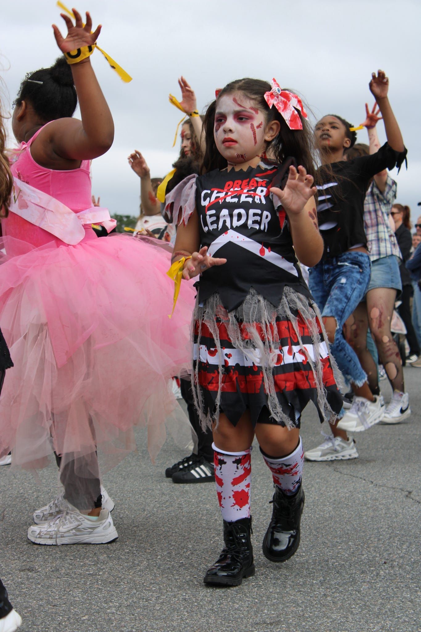 Children dancing in colorful costumes during a street parade