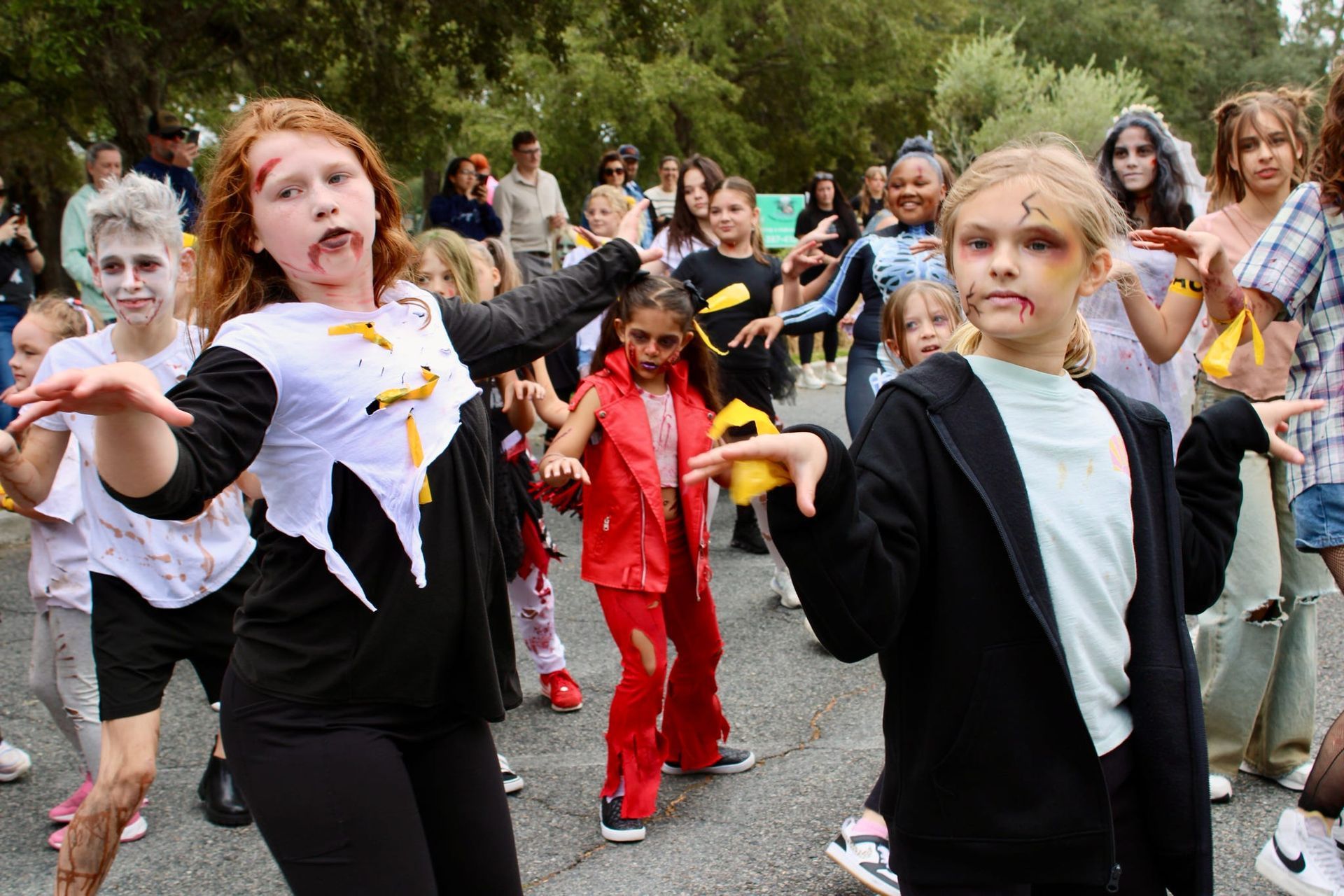 Children in colorful costumes dancing outdoors in a street parade
