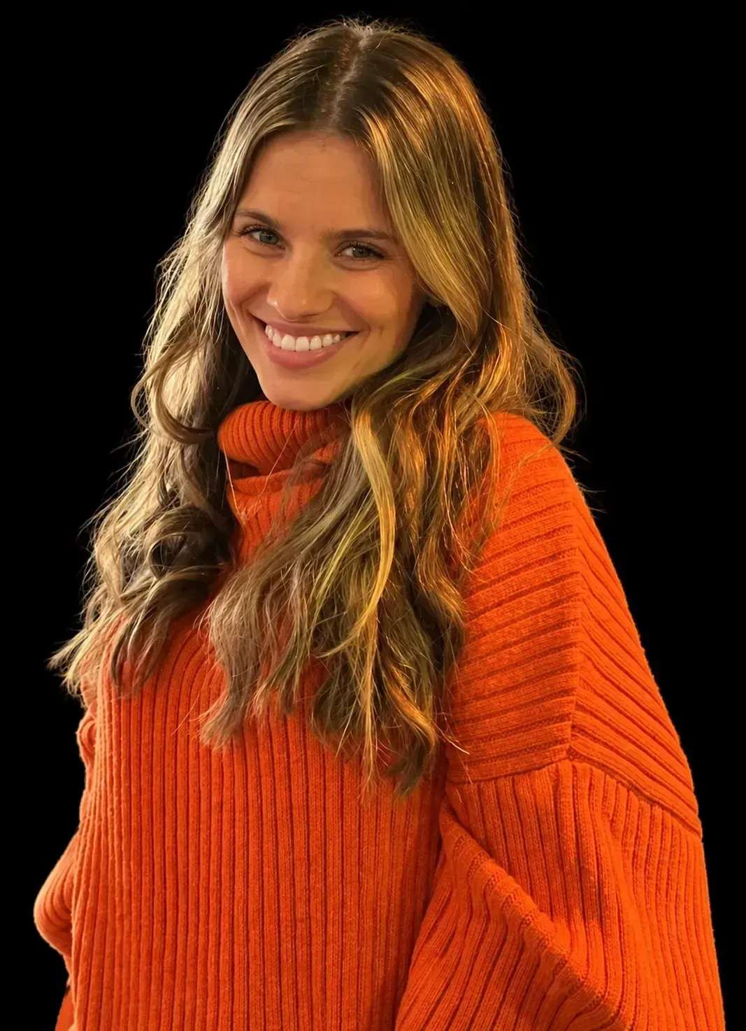 Smiling woman with curly dark hair in a black top against a light background
