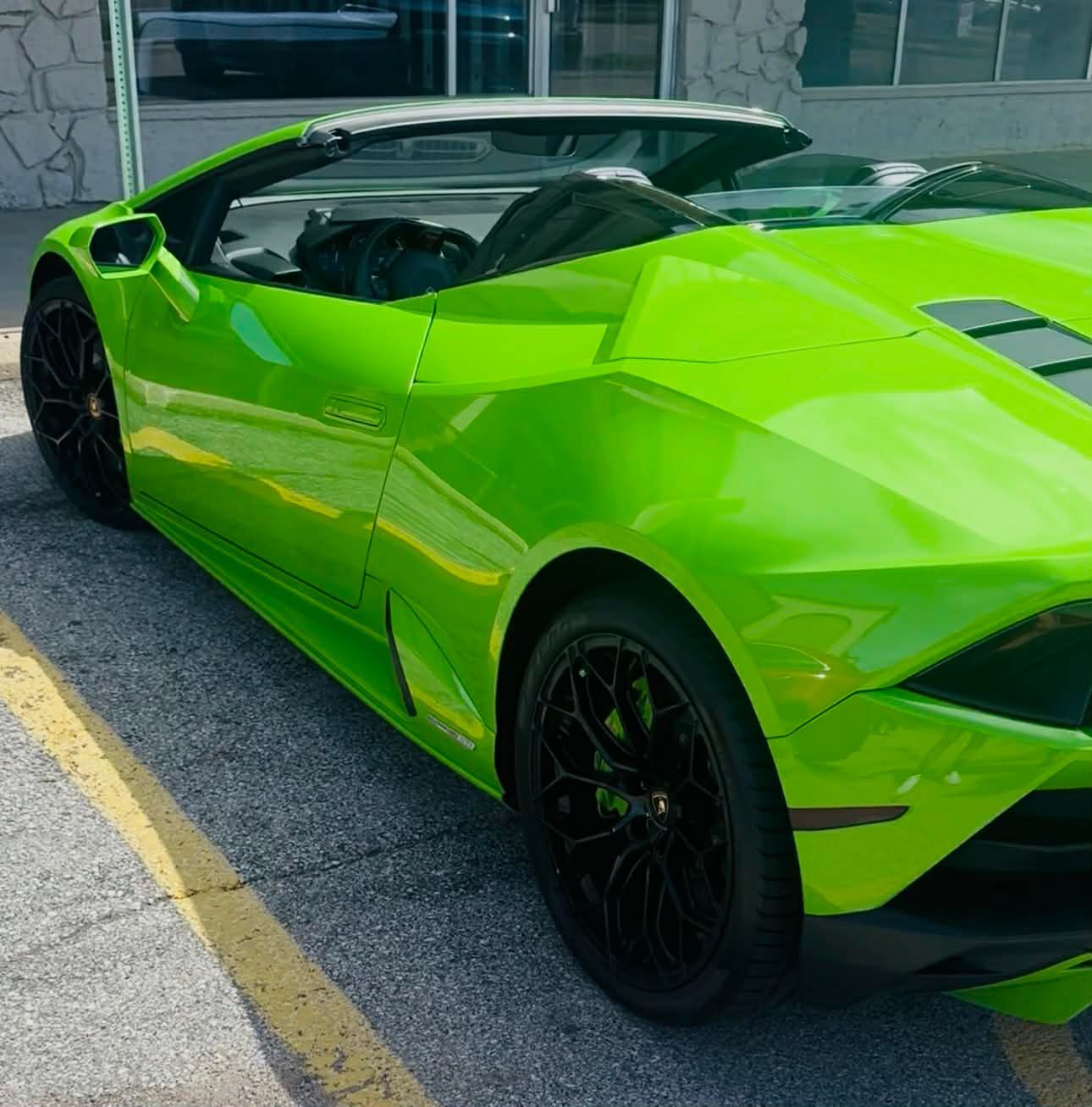 Bright lime green convertible sports car parked outside a building