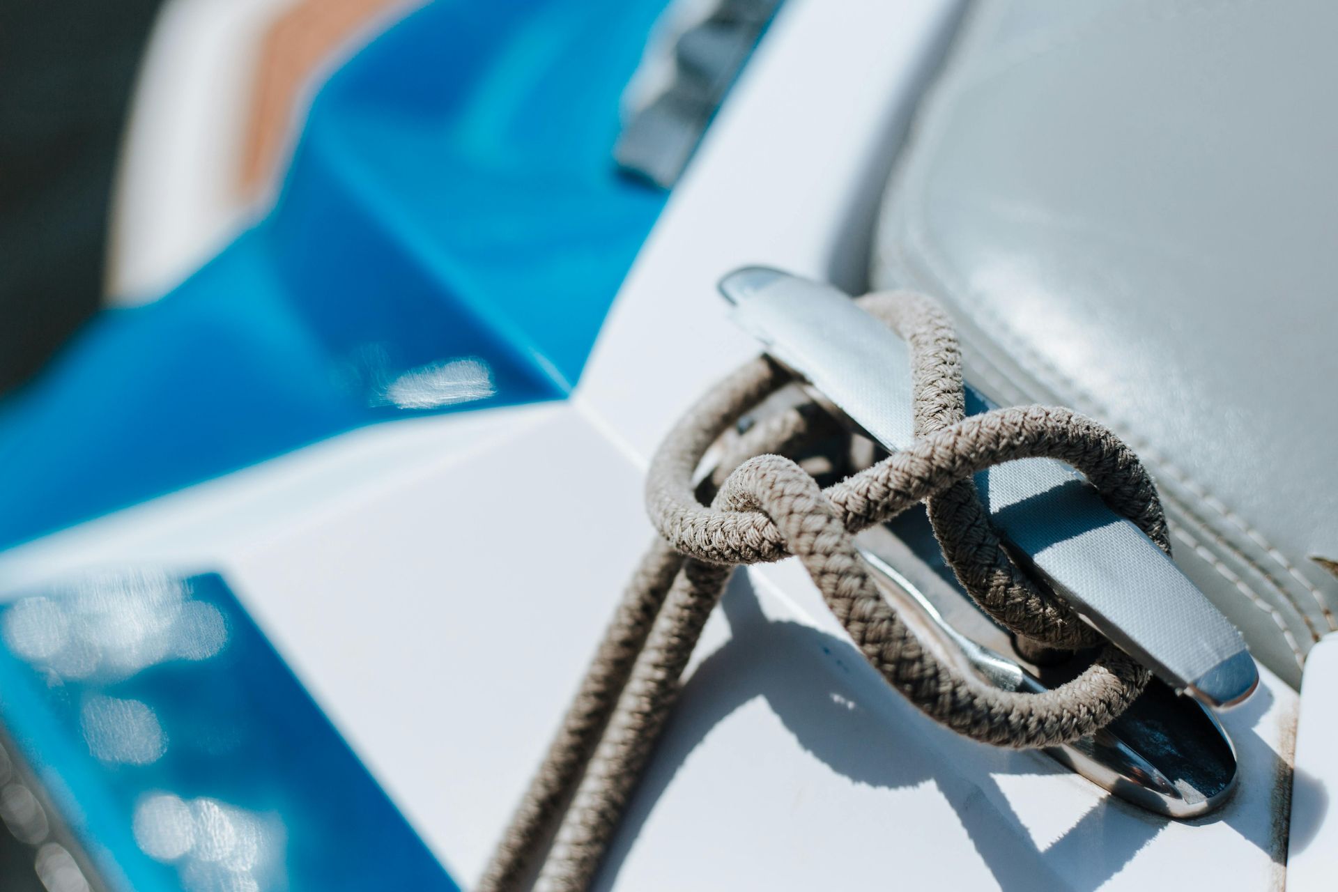 Close-up of a rope knot on a blue and white sailboat sail tack