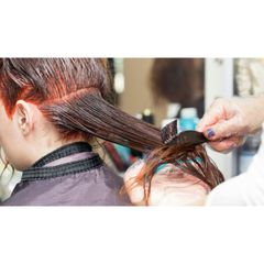 A woman is getting her hair dyed in a salon.