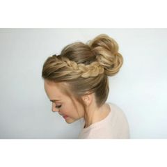 A woman is wearing her hair in a braided bun.