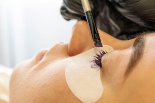 A woman is getting her eyelashes done at a beauty salon.