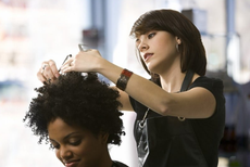 A woman is getting her hair cut by a hairdresser
