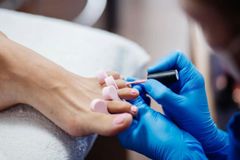 A woman is getting her toenails painted at a nail salon.