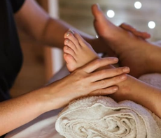 A woman is giving a child a foot massage.