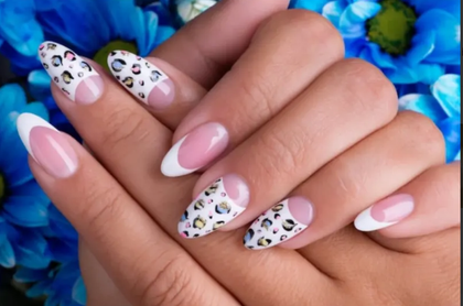 A close up of a woman 's nails with a leopard print design