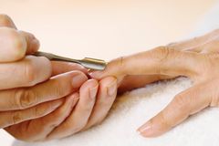 A woman is getting her nails done by a nail technician.