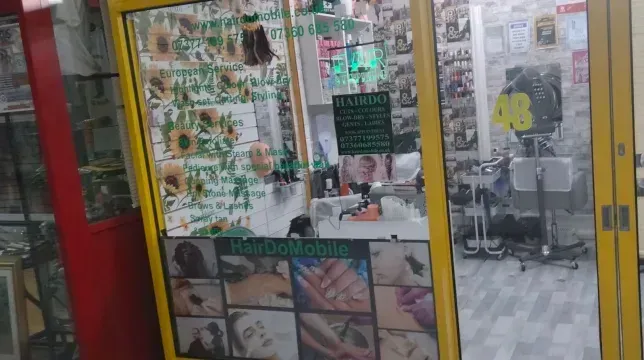 A yellow door with a picture of a nail salon on it.