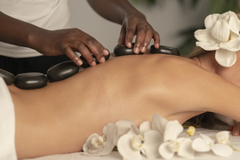 A woman is getting a hot stone massage at a spa.