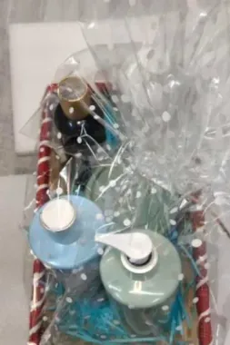A basket filled with bottles of soap wrapped in plastic.