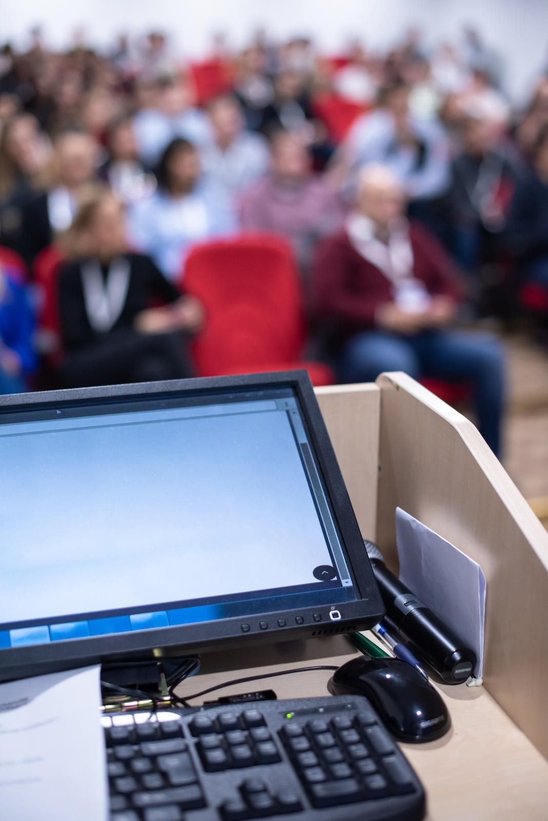 Laptop on a podium in front of an audience