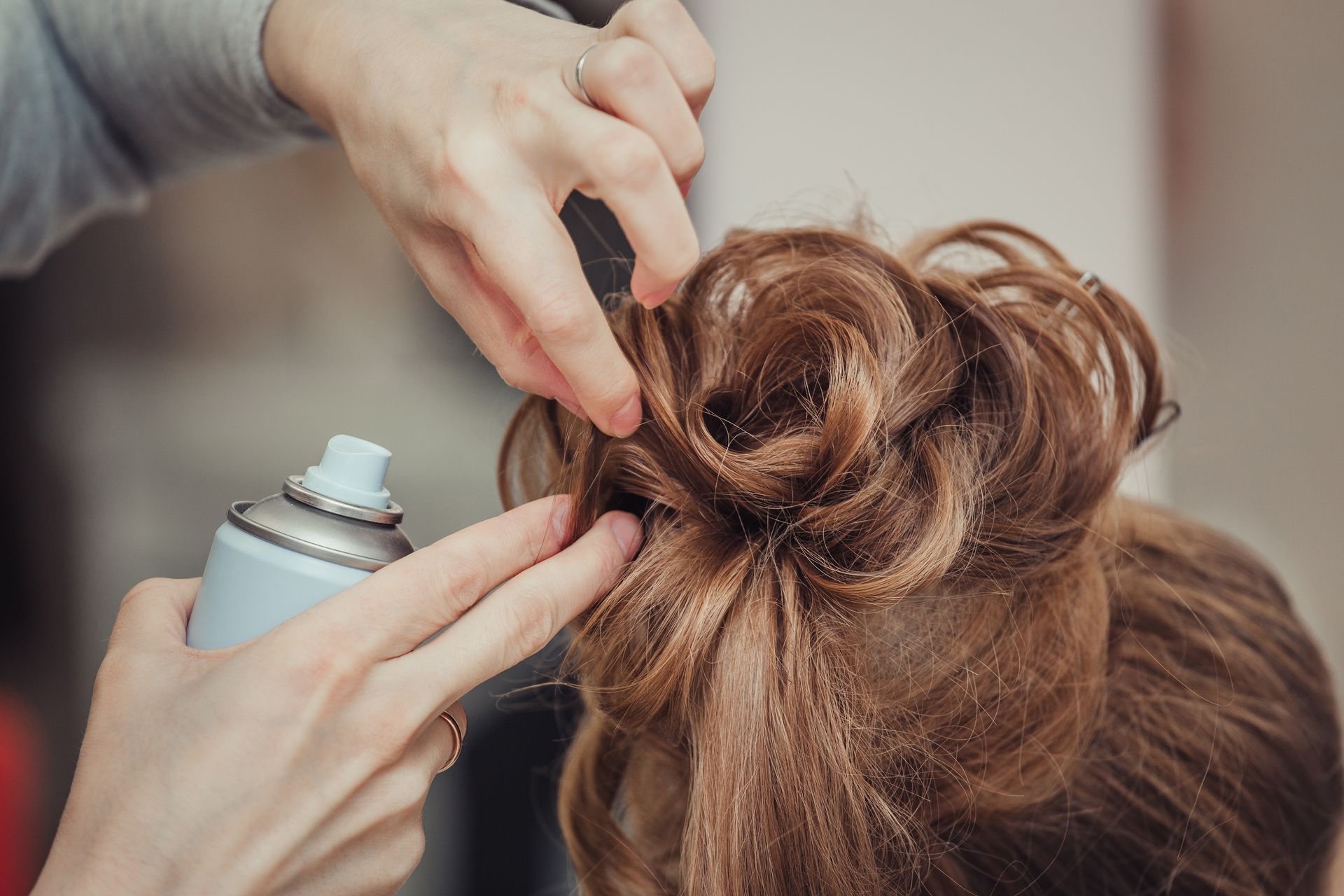A woman is getting her hair done by a hairdresser.