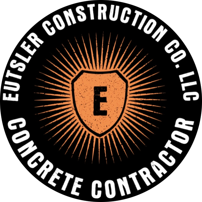 Eutser Construction Co., LLC logo with orange shield and sunburst on black background
