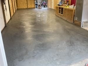 Empty indoor hallway with a polished concrete floor and wood-paneled walls