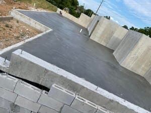 Partially built concrete slab with cinder block walls at a construction site