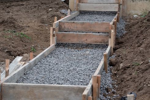 Gravel-filled steps forming a concrete stairway under construction on a dirt slope