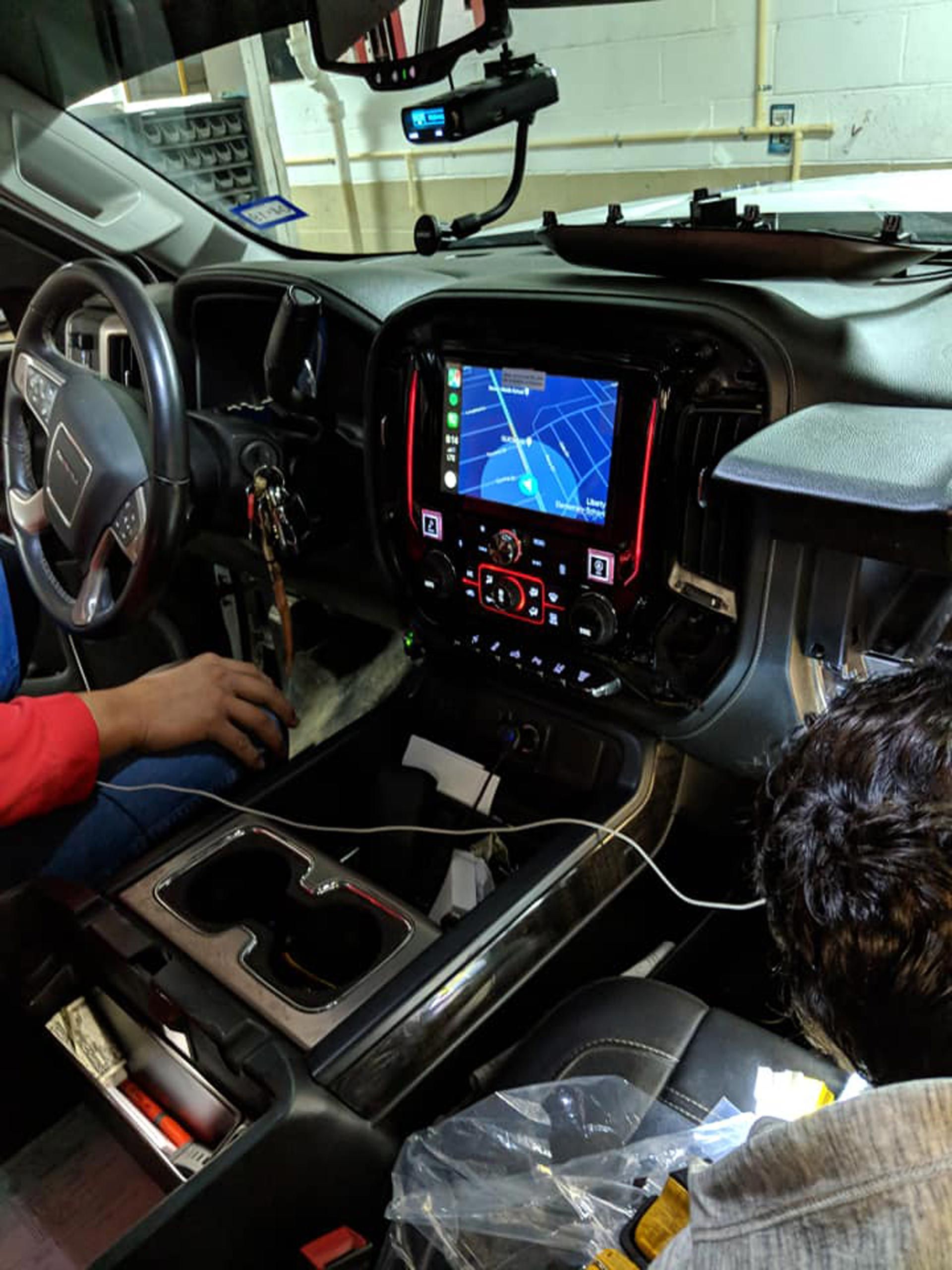 A man is working on the dashboard of a car