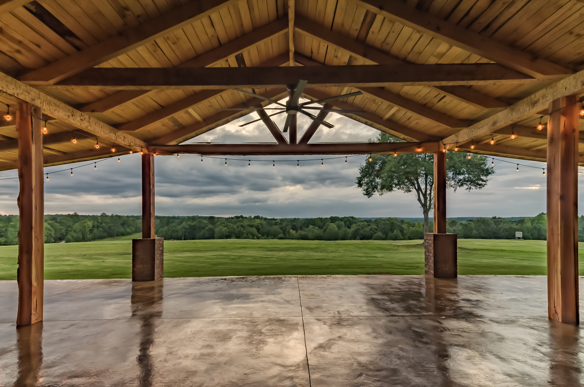 Covered porch overlooking countryside pastures at dusk