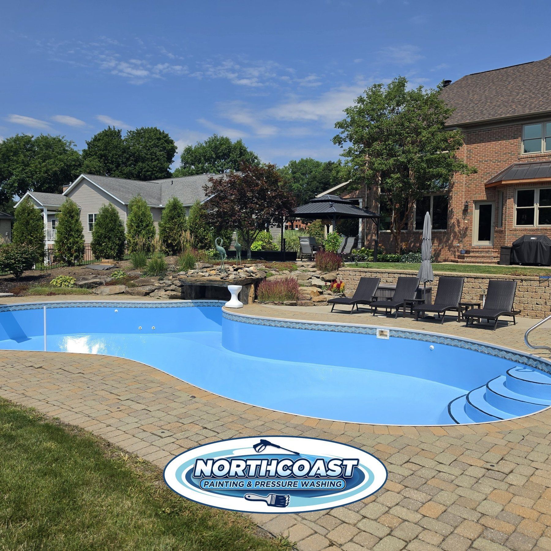 Freshly painted inground swimming pool with a bright blue finish and paver patio