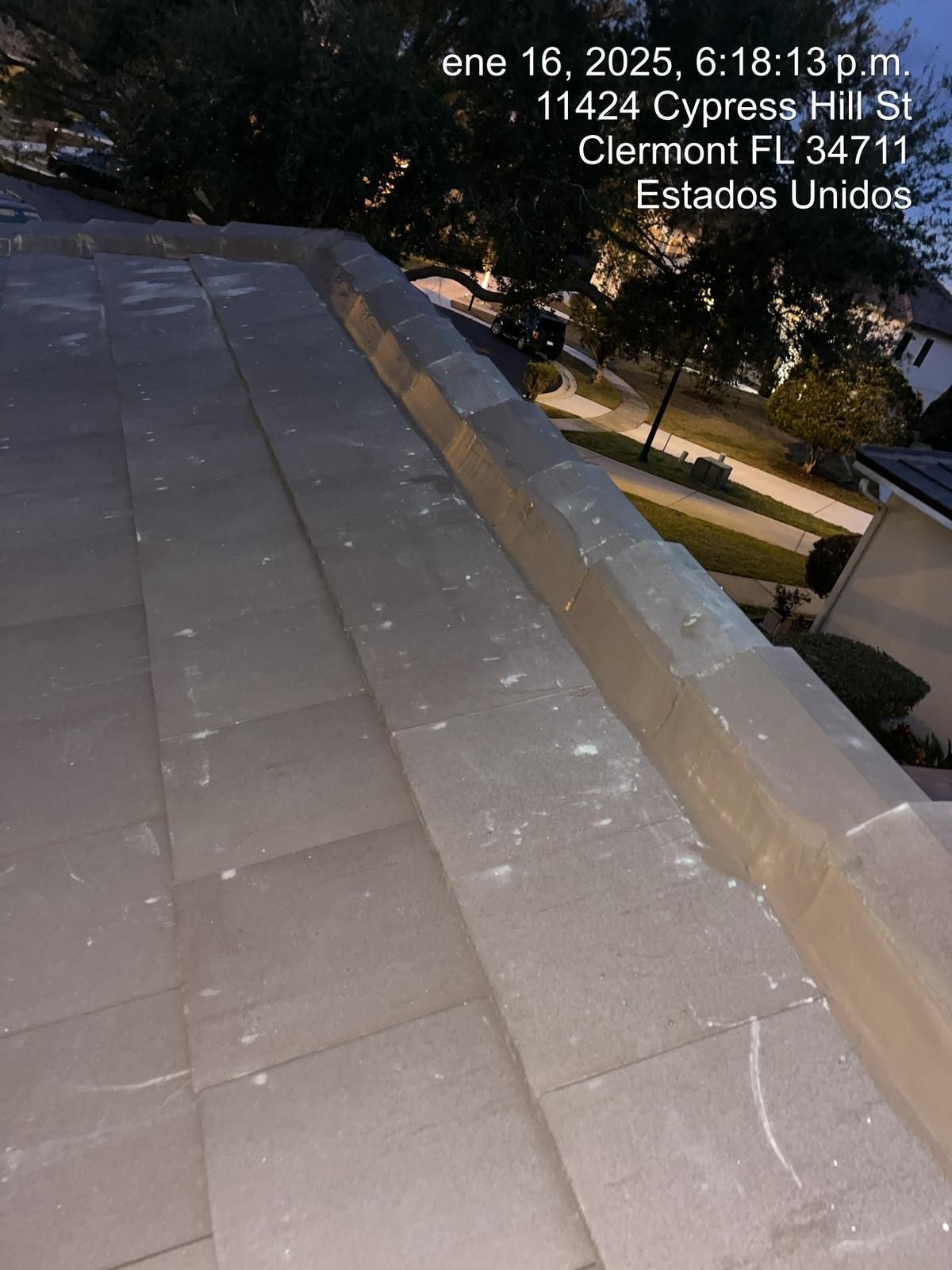 Nighttime rooftop walkway with tan tiles and city lights below, with small text overlay in the corner