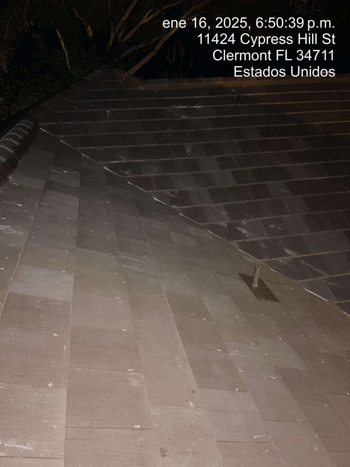 Nighttime view of a dimly lit stone staircase with steps and railing, seen from below.