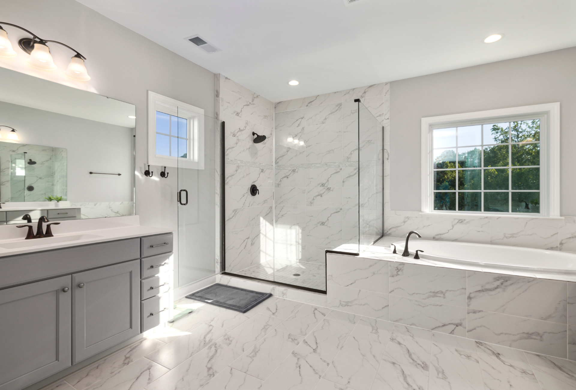 A bathroom with two sinks , a tub , and a walk in shower.
